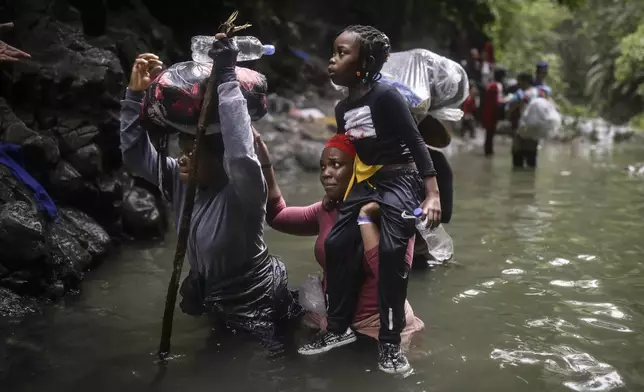Haitian migrants wade through water as they cross the Darien Gap from Colombia to Panama in hopes of reaching the U.S., Tuesday, May 9, 2023. The image was part of a series by Associated Press photographers Ivan Valencia, Eduardo Verdugo, Felix Marquez, Marco Ugarte Fernando Llano, Eric Gay, Gregory Bull and Christian Chavez that won the 2024 Pulitzer Prize for feature photography. (AP Photo/Ivan Valencia)