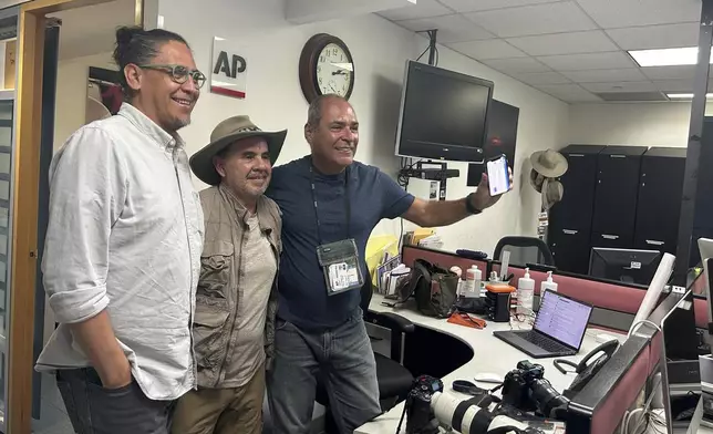 AP photographers, from left, Eduardo Verdugo, Marco Ugarte and Fernando Llano pose for photos after winning the Pulitzer for feature photography, for their images of the migration crisis, at the Associated Press office in Mexico City, Monday, May 6, 2024. Eight AP staff and freelance photographers, six from Latin America and two from the U.S., were awarded this year's Pulitzer for feature photography for images taken in 2023 that documented the anxiety, heartbreak and even the brief moments of joy that mark the migrants' journey. (AP Photo/Megan Janetsky)