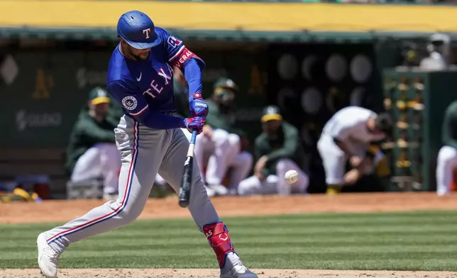 Texas Rangers' Leody Taveras hits a two-run home run against the Oakland Athletics during the fourth inning in the first baseball game of a doubleheader Wednesday, May 8, 2024, in Oakland, Calif. (AP Photo/Godofredo A. Vásquez)
