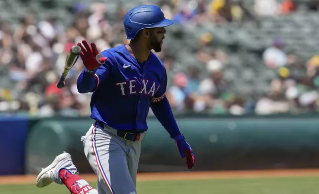 Texas Rangers' Leody Taveras tosses his bat after hitting a two-run home run against the Oakland Athletics during the fourth inning in the first baseball game of a doubleheader Wednesday, May 8, 2024, in Oakland, Calif. (AP Photo/Godofredo A. Vásquez)