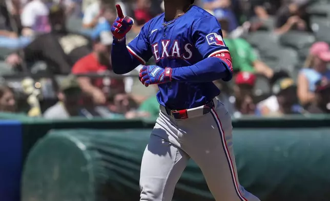 Texas Rangers' Leody Taveras celebrates his two-run home run against the Oakland Athletics during the fourth inning in the first baseball game of a doubleheader Wednesday, May 8, 2024, in Oakland, Calif. (AP Photo/Godofredo A. Vásquez)