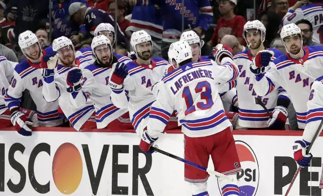 New York Rangers left wing Alexis Lafrenière (13) is congratulated for a goal against the Carolina Hurricanes during the third period in Game 3 of an NHL hockey Stanley Cup second-round playoff series Thursday, May 9, 2024, in Raleigh, N.C. (AP Photo/Chris Seward)