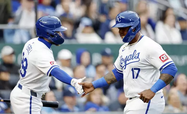 Kansas City Royals' Nelson Velázquez (17) is congratulated at home plate by Kyle Isbel (28) after scoring off a two-run single by Hunter Renfroe (16) during the fifth inning of a baseball game against the Texas Rangers in Kansas City, Mo., Saturday, May 4, 2024. (AP Photo/Colin E. Braley)