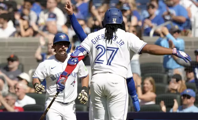 Toronto Blue Jays' Davis Schneider (36) celebrates with Vladimir Guerrero Jr. (27) after scoring on a two-run double hit by Daulton Varsho, not shown, during the fifth inning of a baseball game against the Tampa Bay Rays, Saturday, May 18, 2024, in Toronto. (Chris Young/The Canadian Press via AP)