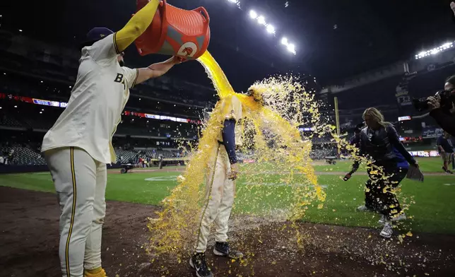 Milwaukee Brewers' Tyler Black is dunked by Willy Adames after a baseball game against the Tampa Bay Rays Tuesday, April 30, 2024, in Milwaukee. (AP Photo/Aaron Gash)