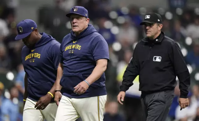 Milwaukee Brewers manager Pat Murphy, middle, walks back to the dugout with Rickie Weeks Jr., left, after being ejected during the sixth inning of a baseball game against the Tampa Bay Rays Tuesday, April 30, 2024, in Milwaukee. (AP Photo/Aaron Gash)