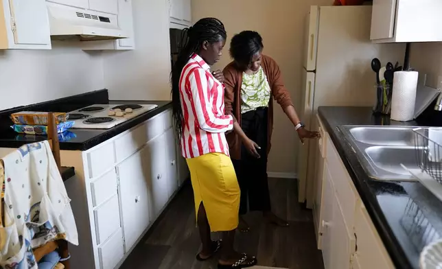 Congo refugee Riziki Kashindi, left, receives a tour of her new apartment from Lutheran Services Carolinas employment specialist Yvonne Songolo, Thursday, April 11, 2024, in Columbia, S.C. The American refugee program, which long served as a haven for people fleeing violence around the world, is rebounding from years of dwindling arrivals under former President Donald Trump. The Biden administration has worked to restaff refugee resettlement agencies and streamline the process of vetting and placing people in America. (AP Photo/Erik Verduzco)