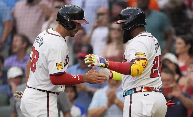 Atlanta Braves designated hitter Marcell Ozuna (20) celebrates with Matt Olson (28) after hitting a three-run hom run in the first inning of a baseball game Wednesday, May 8, 2024, in Atlanta. (AP Photo/John Bazemore)