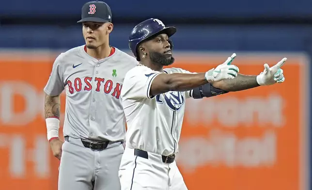 Tampa Bay Rays' Randy Arozarena, right, celebrates his double off Boston Red Sox starting pitcher Cooper Criswell during the first inning of a baseball game Tuesday, May 21, 2024, in St. Petersburg, Fla. Looking on is Boston Red Sox second baseman Vaughn Grissom. (AP Photo/Chris O'Meara)