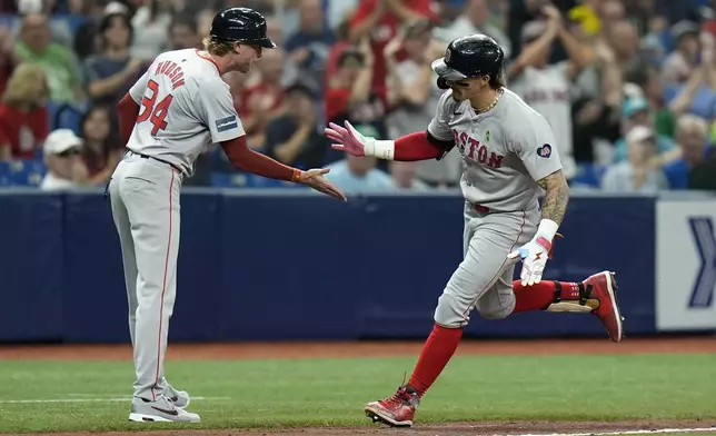 Boston Red Sox's Jarren Duran celebrates his solo home run off Tampa Bay Rays starting pitcher Zack Littell with third base coach Kyle Hudson (84) during the sixth inning of a baseball game Tuesday, May 21, 2024, in St. Petersburg, Fla. (AP Photo/Chris O'Meara)