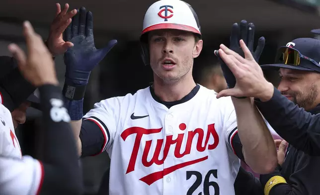 Minnesota Twins' Max Kepler is congratulated after his solo home run against the Boston Red Sox during the fourth inning of a baseball game, Saturday, May 4, 2024, in Minneapolis. (AP Photo/Matt Krohn)