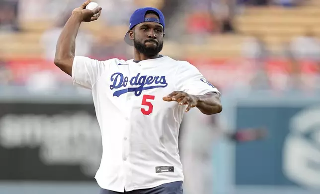 Former NFL and University of Southern California running back Reggie Bush throws out the ceremony first pitch prior to a baseball game between the Los Angeles Dodgers and the Cincinnati Reds Friday, May 17, 2024, in Los Angeles. (AP Photo/Mark J. Terrill)