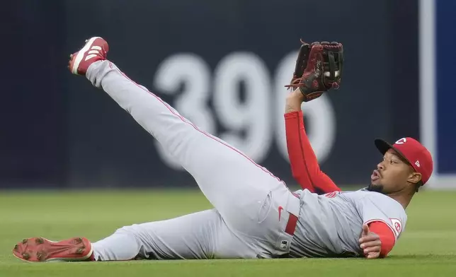 Cincinnati Reds right fielder Will Benson holds on to the ball after making a sliding catch for the out on San Diego Padres' Tyler Wade during the second inning of a baseball game, Tuesday, April 30, 2024, in San Diego. (AP Photo/Gregory Bull)