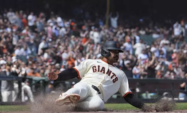 San Francisco Giants' LaMonte Wade Jr. scores against the Colorado Rockies on Luis Matos' single during the eighth inning of a baseball game Saturday, May 18, 2024, in San Francisco. (AP Photo/Godofredo A. Vásquez)