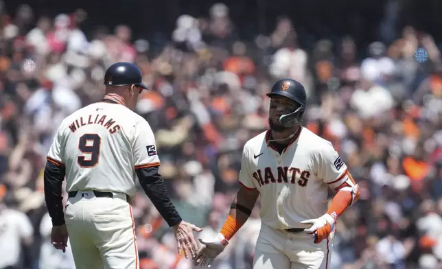 San Francisco Giants' Luis Matos, right, celebrates with third base coach Matt Williams after hitting a three-run home run against the Colorado Rockies during the first inning of a baseball game Saturday, May 18, 2024, in San Francisco. (AP Photo/Godofredo A. Vásquez)