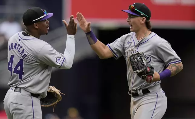 Colorado Rockies left fielder Jordan Beck, right, celebrates with teammate first baseman Elehuris Montero after the Rockies defeated the San Diego Padres 8-0 in a baseball game, Wednesday, May 15, 2024, in San Diego. (AP Photo/Gregory Bull)