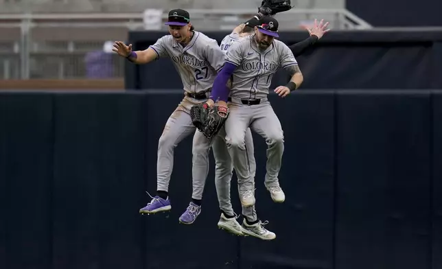 Colorado Rockies left fielder Jordan Beck, left, celebrates with teammates center fielder Brenton Doyle, behind, and right fielder Jake Cave after the Rockies defeated the San Diego Padres 8-0 in a baseball game, Wednesday, May 15, 2024, in San Diego. (AP Photo/Gregory Bull)