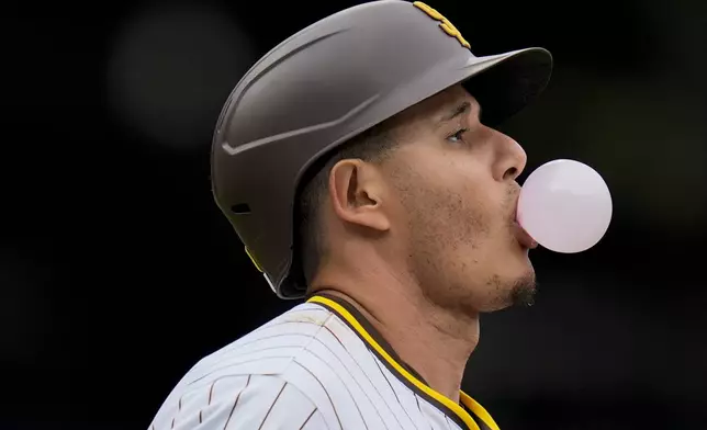 San Diego Padres' Manny Machado blows a bubble on his way towards first base as he grounds out during the ninth inning of a baseball game against the Colorado Rockies, Wednesday, May 15, 2024, in San Diego. The Rockies won, 8-0. (AP Photo/Gregory Bull)