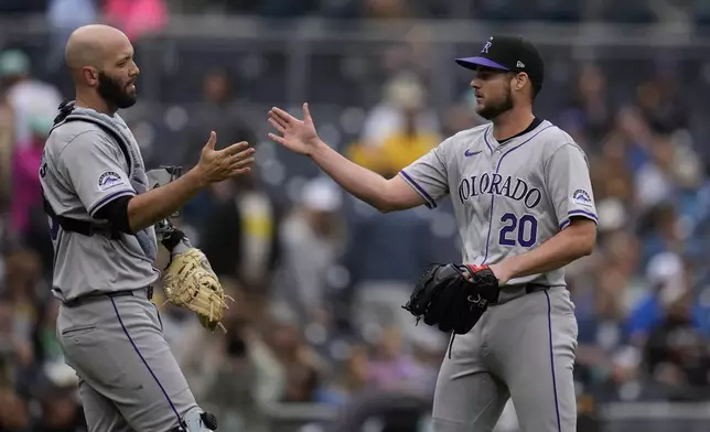 Colorado Rockies relief pitcher Peter Lambert (20) celebrates with catcher Jacob Stallings after the Rockies defeated the San Diego Padres 8-0 in a baseball game, Wednesday, May 15, 2024, in San Diego. (AP Photo/Gregory Bull)