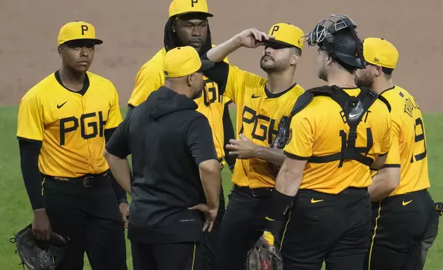 Pittsburgh Pirates pitcher Martín Pérez, third from right, gets a visit from pitching coach Oscar Marin during the sixth inning of a baseball game against the Colorado Rockies in Pittsburgh, Friday, May 3, 2024. (AP Photo/Gene J. Puskar)