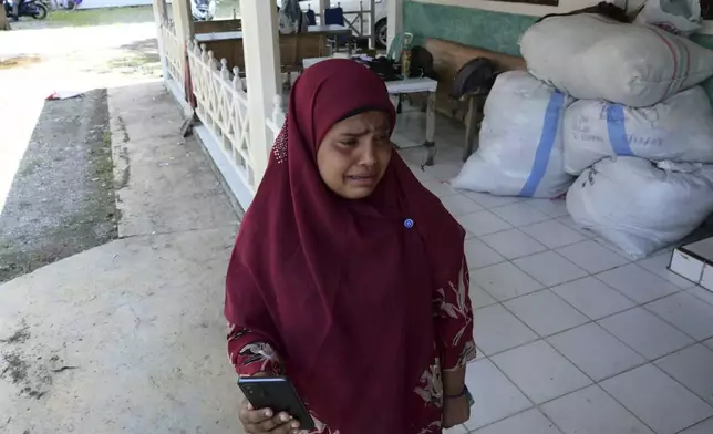 Fatima Khatun, a Rohingya survivor of a capsized refugee boat, cries as she calls her son in Bangladesh from a temporary shelter in Meulaboh, Indonesia, on Wednesday, April 3, 2024. Fatima was among 75 people rescued in March from atop the overturned hull of the boat. Dozens of others, including Fatima's 8-year-old daughter, died. (AP Photo/Reza Saifullah)