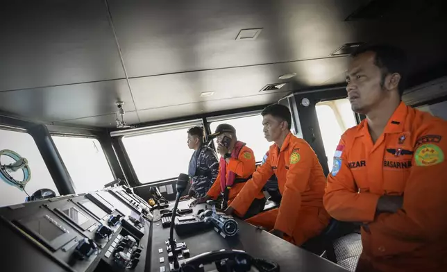 Members of Indonesia's National Search and Rescue Agency scan the horizon during the search for a capsized boat carrying Rohingya refugees off West Aceh, Indonesia, on Thursday, March 21, 2024. The wooden fishing boat carried about 140 Rohingya refugees, but only 75 people were rescued. In interviews with The Associated Press, eight of the survivors described abuses on board the fishing boat. (AP Photo/Reza Saifullah)