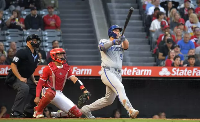 Kansas City Royals' Vinnie Pasquantino, right, hits a two-run home run as Los Angeles Angels catcher Logan O'Hoppe, center, watches along with home plate umpire Stu Scheurwater during the third inning of a baseball game Thursday, May 9, 2024, in Anaheim, Calif. (AP Photo/Mark J. Terrill)