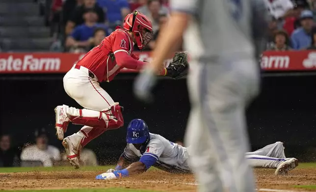 Kansas City Royals' Dairon Blanco, center, scores on a sacrifice fly by Vinnie Pasquantino, right, as Los Angeles Angels catcher Logan O'Hoppe attempts a late tag during the fifth inning of a baseball game Thursday, May 9, 2024, in Anaheim, Calif. (AP Photo/Mark J. Terrill)