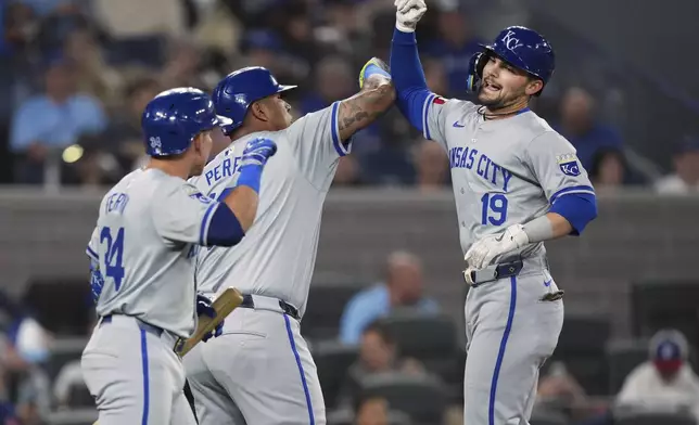 Kansas City Royals' Michael Massey (19) celebrates with teammates Salvador Perez (13) and Freddy Fermin (34) after hitting a two-run home run during the first inning of a baseball game against the Toronto Blue Jays, Tuesday, April 30, 2024 in Toronto.(Nathan Denette/The Canadian Press via AP)