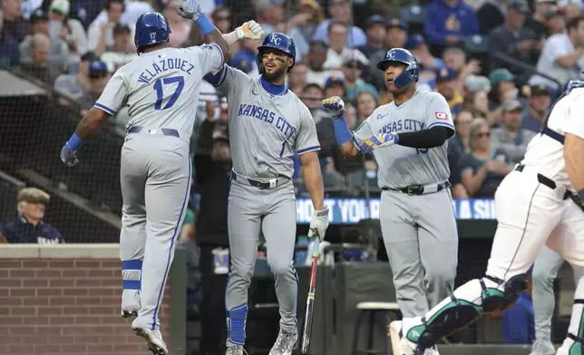 Kansas City Royals' Nelson Velazquez (17) celebrates with MJ Melendez (1) and Salvador Perez after hitting a three-run home run against the Seattle Mariners during the seventh inning of a baseball game Tuesday, May 14, 2024, in Seattle. (AP Photo/Jason Redmond)