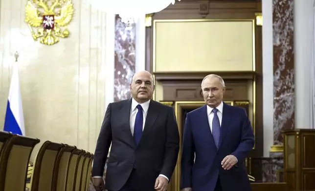 Russian President Vladimir Putin, right, escorted by Russian Prime Minister Mikhail Mishustin arrives for a meeting with Cabinet members in Moscow, Russia, Monday, May 6, 2024. Putin thanked Cabinet ministers for their work ahead of his inauguration Tuesday. (Dmitry Astakhov, Sputnik, Government Pool Photo via AP)
