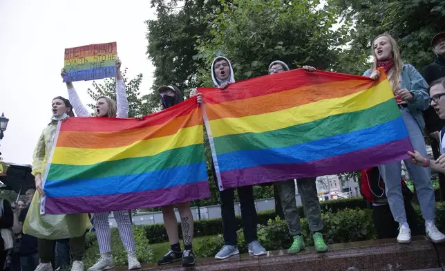 FILE – LGBTQ+ activists wave flags during a rally in Moscow, Russia, Wednesday, July 15, 2020. The Kremlin targets such activists as well as independent media, rights groups and others who don't hew to what President Vladimir Putin has emphasized as Russia's “traditional family values.” (AP Photo, File)