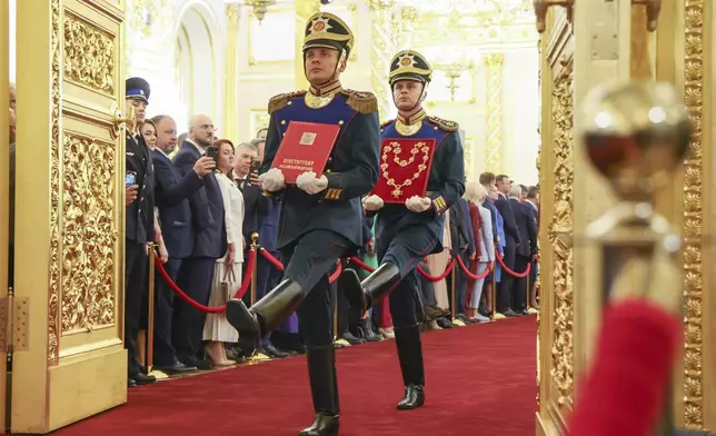 Honour guards of the Presidential regiment carry a special copy of the Russian Constitution and the President's Badge prior to an inauguration ceremony of Vladimir Putin as Russian president in the Grand Kremlin Palace in Moscow, Russia, Tuesday, May 7, 2024. (Alexander Kazakov, Sputnik, Kremlin Pool Photo via AP)