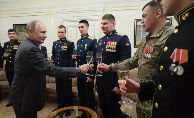 FILE - Russian President Vladimir Putin, left, shares a toast with servicemen at the Novo-Ogaryovo State residence outside Moscow, Russia, on Monday, Jan. 1, 2024. With the fighting in Ukraine in its third year, Putin hopes Western support for Ukraine will wither while Moscow maintains its steady military pressure. (Gavriil Grigorov, Sputnik, Kremlin Pool Photo via AP, File)
