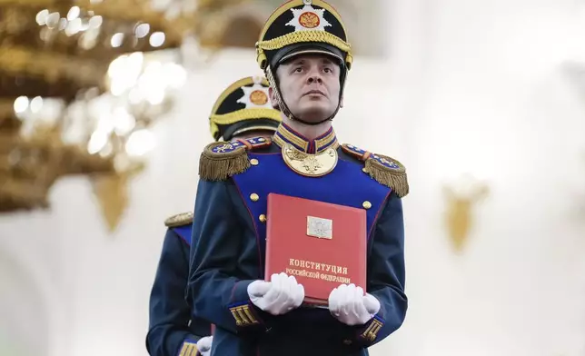A Honour guard soldier carries the Russian Constitution during Vladimir Putin's inauguration ceremony as Russian president in the Grand Kremlin Palace in Moscow, Russia, Tuesday, May 7, 2024. (AP Photo/Alexander Zemlianichenko, Pool)