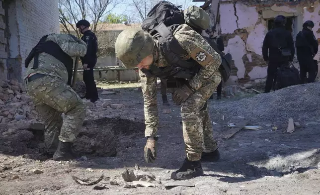 FILE - A police officer examines fragments of a guided bomb after the Russian air raid in Kharkiv, Ukraine, Tuesday, April 30, 2024. Russia pounded a town in Ukraine’s northeast with artillery, rockets and guided aerial bombs Friday May 10, 2024 before attempting an infantry breach of local defenses, authorities said, in a tactical switch that Kyiv officials have been expecting for weeks as the war stretches into its third year. (AP Photo/Andrii Marienko, File)