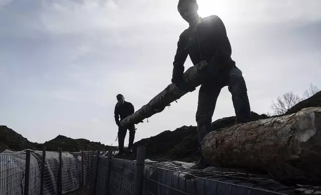 Workers construct new defensive positions close to the Russian border in Kharkiv region, Ukraine, on Wednesday, April 17, 2024. (AP Photo/Evgeniy Maloletka)
