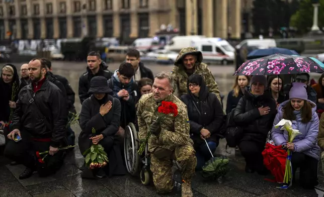 Family, friends and army comrades gather to pay respect to Ukrainian army paramedic Nazarii Lavrovskyi, 31, killed in the war, during his funeral ceremony at Independence square in Kyiv, Wednesday, April 24, 2024. (AP Photo/Francisco Seco)