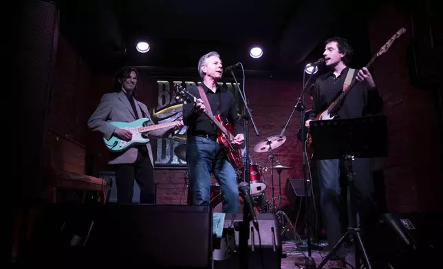 US Secretary of State Antony Blinken, center, performs "Rockin' in the Free World" with members of The 1999 band at the Barman Dictat bar in Kyiv, Tuesday, May 14, 2024. Blinken sought Tuesday to rally the spirits of glum Ukrainians facing a fierce new Russian offensive, assuring them that they are not alone and that billions of dollars in American military aid on its way to the country would make a “real difference” on the battlefield. (Brendan Smialowski/Pool photo via AP)