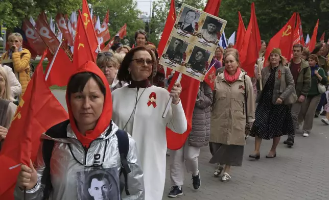 People walk with portraits of relatives who fought in World War II, during the Immortal Regiment action celebrating the 79th anniversary of the end of World War II, in Sevastopol, Crimea, Thursday, May 9, 2024. (AP Photo)