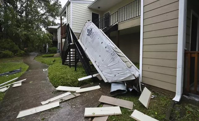 A chimney and siding, blown off a roof by extreme winds, rests in a stairwell at an apartment complex in Tallahassee, Fla., Friday, May 10, 2024. Powerful storms with damaging high winds threatened several states in the Southeast early Friday. (AP Photo/Phil Sears)