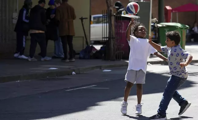 Children play with a basketball in the Tenderloin neighborhood Saturday, April 20, 2024, in San Francisco. (AP Photo/Godofredo A. Vásquez)