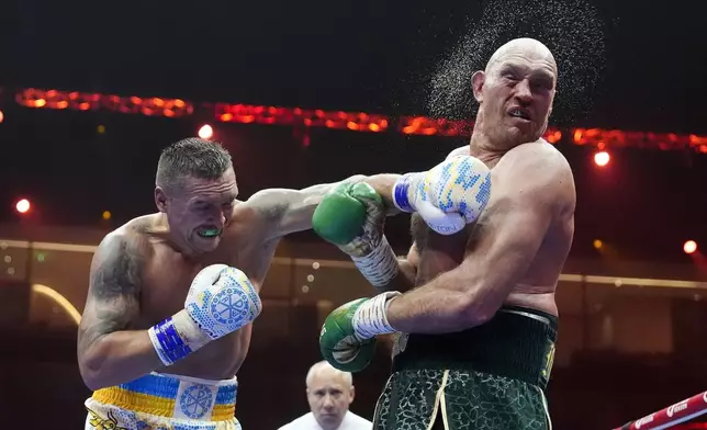 Britain’s Tyson Fury, right, takes a blow from Ukraine’s Oleksandr Usyk during their undisputed heavyweight world championship boxing fight at the Kingdom Arena in Riyadh, Saudi Arabia, Sunday, May 19, 2024. (Nick Potts/PA via AP)