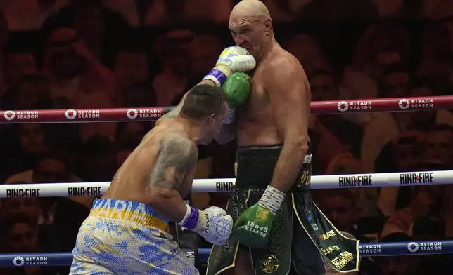 Ukraine's Oleksandr Usyk, left, lands a blow on Britain's Tyson Fury during their undisputed heavyweight world championship boxing fight at the Kingdom Arena in Riyadh, Saudi Arabia, Sunday, May 19, 2024. (AP Photo/Francisco Seco)