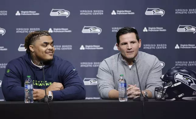Seattle Seahawks 2024 first round draft pick, Byron Murphy II, left, listens as a head coach Mike Macdonald, right, speaks during a news conference at the NFL team's headquarters, Thursday, May 2, 2024, in Renton, Wash. (AP Photo/John Froschauer)