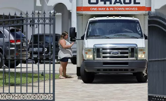 A woman leaves Sean Kingston's Southwest Ranches, Fla., home Thursday, May 23, 2024. Attorney Dennis Card said she was one of the owners of an $80,000 bed and had flown in from Utah to retrieve it. A SWAT team raided rapper Kingston's rented mansion on Thursday, and arrested his mother on fraud and theft charges that an attorney says stems partly from the installation of a massive TV at the home. (Amy Beth Bennett/South Florida Sun-Sentinel via AP)