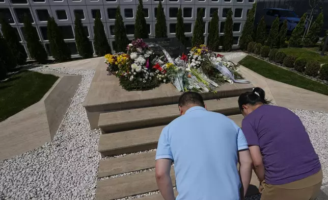 Visitors from China take a bow in front of a black-marble monument and to lay flowers in honor of the victims of the 1999 bombing, in Belgrade, Serbia, Saturday, May 4, 2024. Chinese leader Xi Jinping's visit to European ally Serbia on Tuesday falls on a symbolic date: the 25th anniversary of the bombing of the Chinese Embassy in Belgrade during NATO's air war over Kosovo. (AP Photo/Darko Vojinovic)