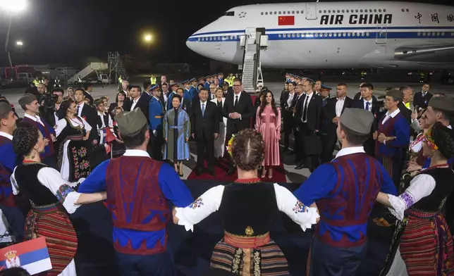 In this photo provided by the Serbian Presidential Press Service, Serbian President Aleksandar Vucic, center right, welcomes Chinese President Xi Jinping, center left, and his wife Peng Liyuan during a welcome ceremony upon his arrival at the Nikola Tesla airport in Belgrade, Serbia, Tuesday, May 7, 2024. (Serbian Presidential Press Service via AP)