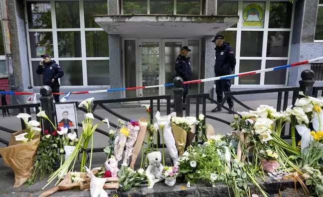 FILE - Police officers guard the Vladimir Ribnikar school in Belgrade, Serbia, Thursday, May 4, 2023. A teenage boy opened fire at the school on the morning of May 3, 2023. Eight children and a school guard died, and seven people were wounded. One of the wounded, a child, died from injuries later. A total of 10 people were killed. (AP Photo/Darko Vojinovic, File)