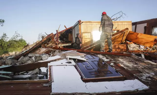 People look through a damaged property after powerful storms hit the area, Tuesday, May 7, 2024 in Barnsdall, Okla. (Mike Simons/Tulsa World via AP)
